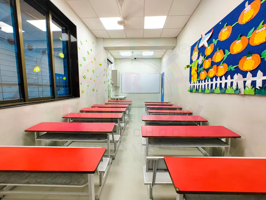 Red tables and a projector in a Rainbow nursery school classroom