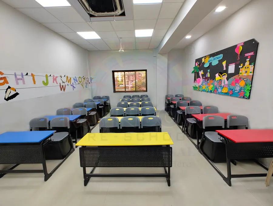 Colourful desks and an alphabet wall in a Rainbow play school classroom