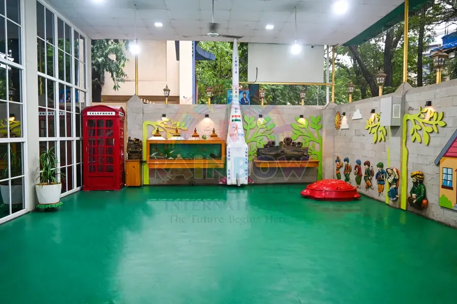 Green-floored children's play area with colourful wall murals and toys