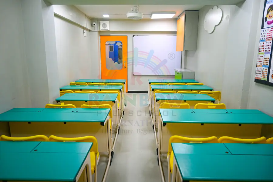 Turquoise tables and yellow chairs in a Rainbow preschool classroom
