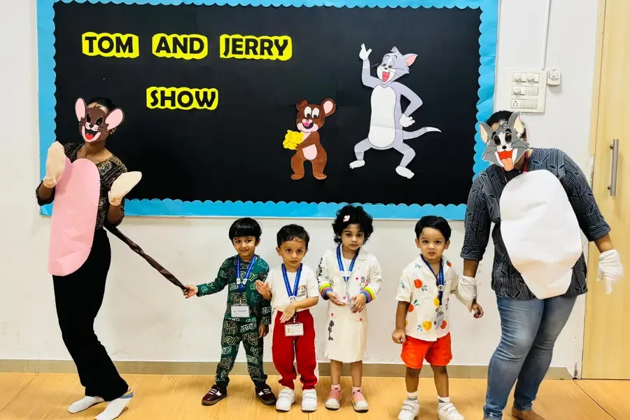 Children standing with costumed cartoon characters at a preschool event