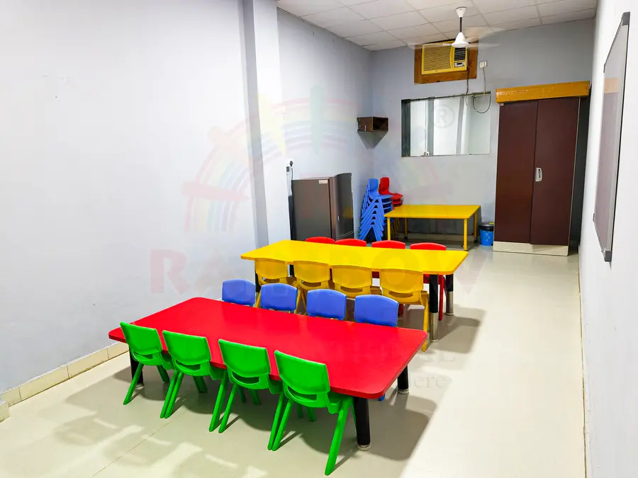 Colourful Rainbow Preschool daycare activity room with child-sized tables and chairs
